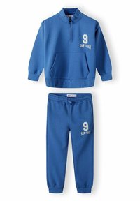Blauwe twee-delige trainingsoutfit met een ritssluiting sweatshirt met een voorzak, gecombineerd met elastische broeken, beide voorzien van het nummer "9" en "SAN FRAN."