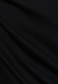 Tessuto nero con una superficie liscia e leggermente texturizzata, caratterizzato da delicate pieghe e drappeggi, che suggeriscono flessibilità e comfort.