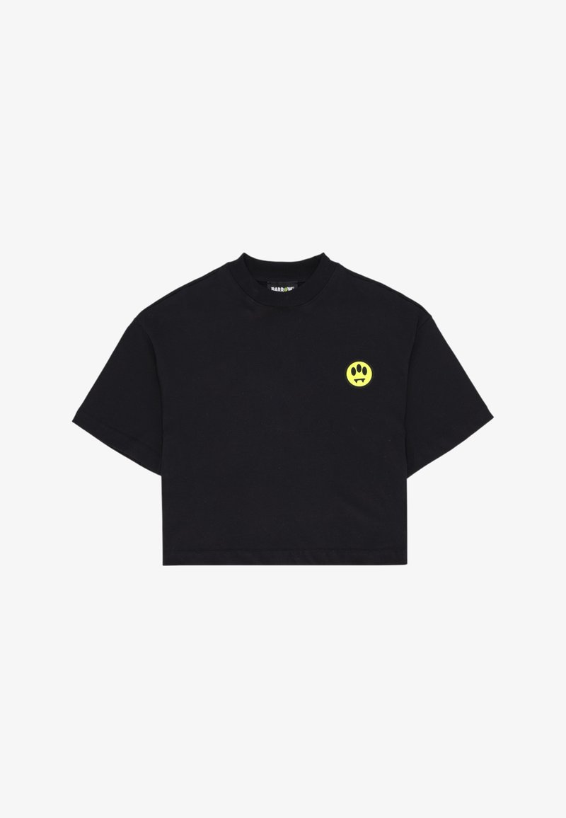 T-shirt noir court à manches courtes, col rond, avec petit logo jaune de visage souriant avec des crocs sur la poitrine gauche.
