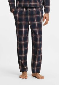 Marinblå rutiga pyjamas med röda och vita detaljer, med en avslappnad passform, mjukt bomullstyg och ett elastiskt midjeband för komfort.