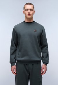 Donkergroene sweatshirt met een ronde hals, geribbelde manchetten en een klein logo-opdruk op de borst; geweven stof. Gepaard met bijpassende broek.
