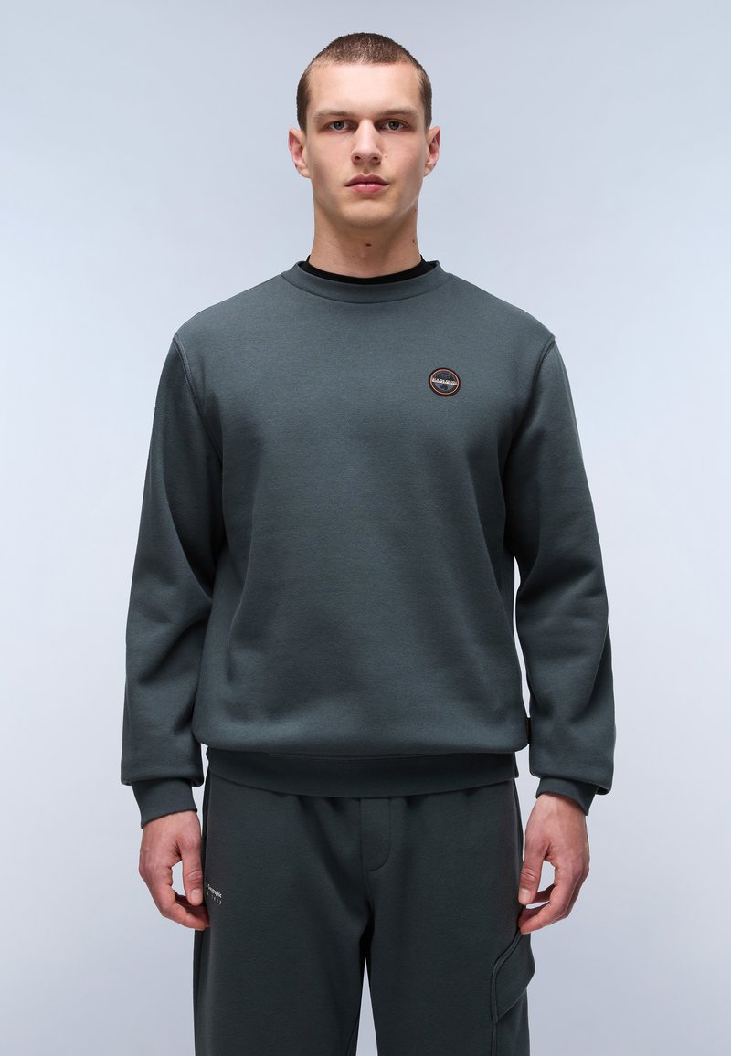 Donkergroene sweatshirt met een ronde hals, geribbelde manchetten en een klein logo-opdruk op de borst; geweven stof. Gepaard met bijpassende broek.