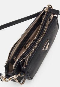 Schwarze Handtasche mit Struktur und goldfarbenen Beschlägen, ausgestattet mit mehreren Reißverschlussfächern und einem abnehmbaren Riemen für vielseitige Tragemöglichkeiten.