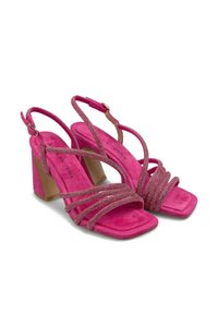 Sandalias de tacón de ante rosa con múltiples tiras entrecruzadas. Diseño de punta cuadrada, acentos metálicos y un tacón ancho para mayor estabilidad.