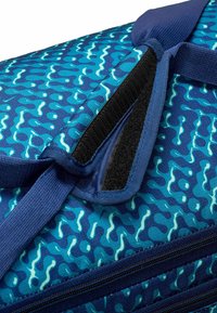 Blauwe tas met een golvend patroon, gemaakt van duurzaam stof. Inclusief een blauwe schouderband en een ritsvak met een klittenbandsluiting.