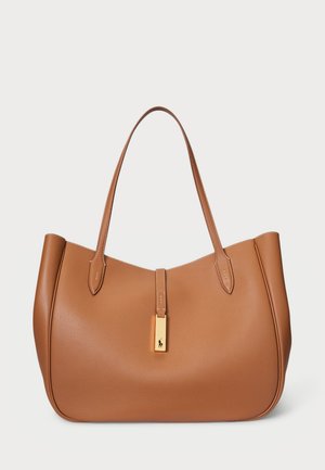 Bolso tote de cuero marrón con forma redondeada, textura suave y dos asas para el hombro. Presenta un acento de hardware dorado en el centro.