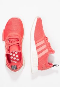 Korálové sportovní boty s texturovaným pleteným svrškem, třemi bílými pruhy, polstrovaným jazykem a bílou podešví s boost technologií. Šestiboký vzor na stélce.