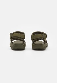 Olivengrønne sandaler med justerbare stofremmer, polstret såle og tekstureret gummisål for godt greb. Designet til komfort og stabilitet.