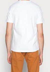 White cotton t-shirt with short sleeves and a crew neck, featuring a smooth texture. The back shows plain design without embellishments.