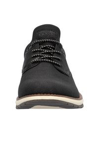 Chaussure noire à lacets avec un dessus en tissu texturé, semelle intermédiaire blanche contrastante et semelle extérieure en caoutchouc marron. Présente des lacets ronds et des accents cousus.