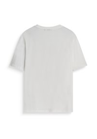 T-shirt bianco a maniche corte mostrato da dietro su uno sfondo bianco.