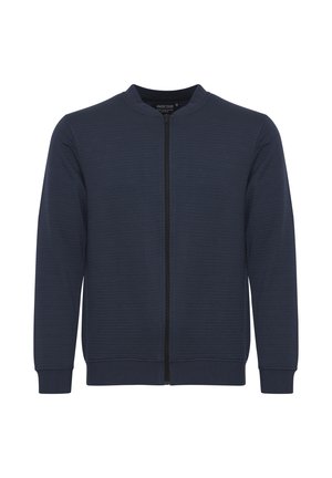 Marine blauwe zip-up jas met ribbelstructuur, ronde halslijn en lange mouwen. Voorzien van een centrale rits en elastische manchetten en zoom.