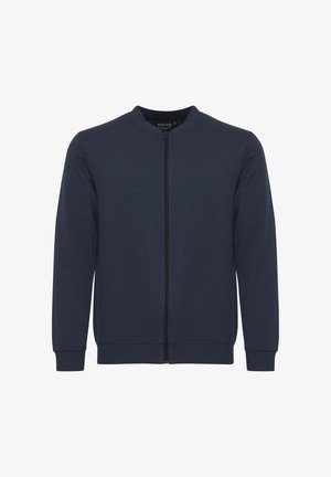 Granatowa kurtka na zamek z prążkowaną teksturą, okrągłym dekoltem i długimi rękawami. Posiada centralny zamek oraz elastyczne mankiety i dół.