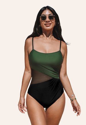 One-piece swimsuit with green top and black bottom, featuring mesh detailing and adjustable straps. Smooth texture with a fitted silhouette.