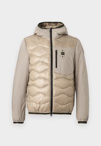 Beige gewatteerde jas met een doorgestikt patroon, capuchon en ritssluiting aan de voorkant. Voorzien van een borstzak en ribgebreide manchetten met contrasterende afwerking.