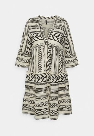 Robe beige et noire longueur genou avec des motifs géométriques et tribaux, manches cloche trois-quarts et profond décolleté en V.