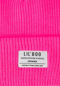 Ružová pletená čiapka s ribovanou štruktúrou a štítkom s nápisom "LIL'BOO, DANSKÉ DESIGNOVÉ ŠTÚDIA, KODAŇ, UDRŽUJEME HYGGE OD ROKU 2015."