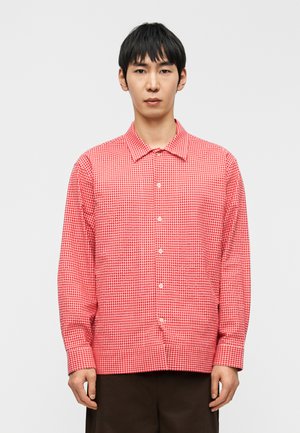 Red checkered long-sleeve shirt with a button-down collar, made of lightweight fabric, features a grid pattern and front buttons.