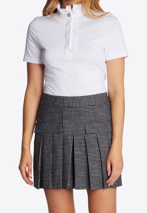 Blusa blanca de manga corta con cuello volante y botón, combinada con una falda plisada de cuadros que presenta bolsillos de parche y un patrón de cuadros.