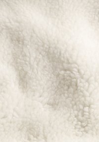 White, fluffy fabric texture with high pile and soft feel, featuring a dense and cozy appearance. No visible patterns or hardware.