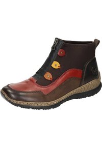 Bottines en cuir marron et rouge avec fermeture éclair, présentant des accents circulaires colorés et une semelle en caoutchouc texturée.