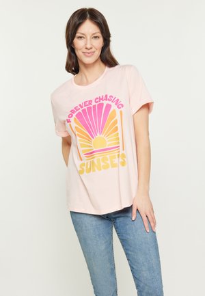 Tricou roz deschis cu manșon scurt, având un grafic de soare cu gradient în nuanțe de portocaliu, roz și galben, cu textul "ÎNTREAGA VIAȚĂ ÎN URMA APUSURILOR."
