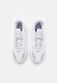 Paire de baskets blanches avec lacets, embouts perforés et col rembourré vue de dessus sur fond blanc.
