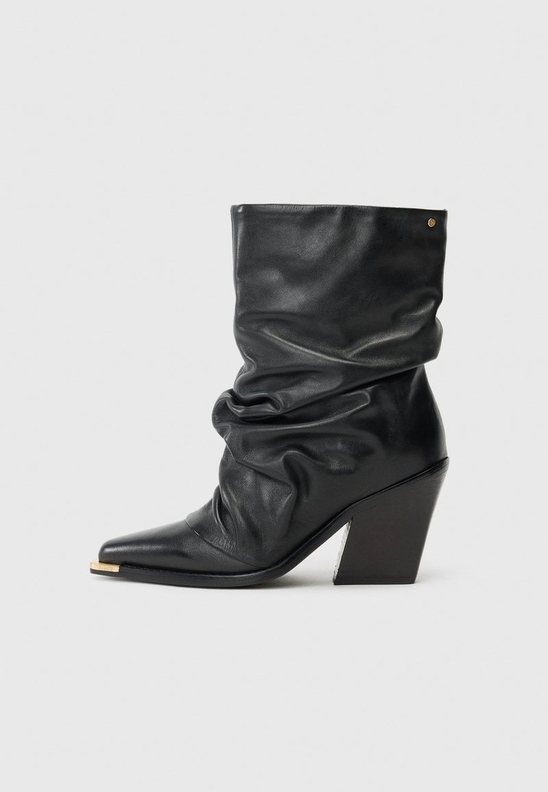 Botine negre din piele cu un design lejer, vârf ascuțit și toc îngust. Prezintă un accent auriu pe vârf și o textură netedă.