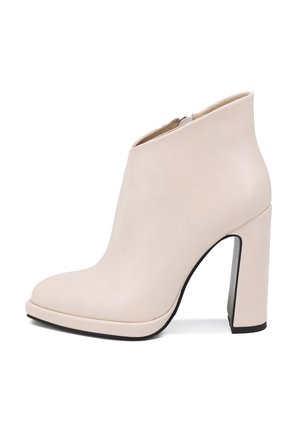 Stivaletto in pelle beige con punta rotonda, tacco alto a blocco e finitura liscia; presenta una cerniera laterale per la chiusura.