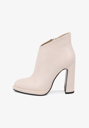 Stivaletto in pelle beige con punta rotonda, tacco alto a blocco e finitura liscia; presenta una cerniera laterale per la chiusura.