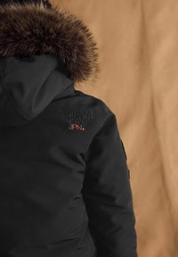 Čierna prešívaná bunda s kapucňou podšitou umelou kožušinou, vyšitým logom "SUPER DRY JPN" v oranžovej farbe, s hladkou textúrou a praktickým dizajnom.