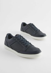 Sneaker navy realizzato in materiale sintetico liscio con accenti perforati, punta tonda, suola piatta in gomma bianca e sei occhielli per i lacci.