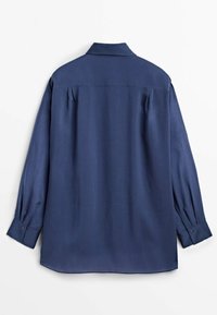 Chemise bleu marine à manches longues avec poignets boutonnés, un col et des plis sur les épaules arrière, présentée à plat sur fond blanc.