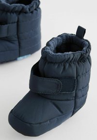 Mørkeblå polstrede babystøvler med blødt fleece-inderside, velcro-lukning og en tekstureret overflade for godt greb.