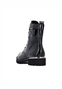 Bottine en cuir noir avec une finition brillante, dotée d'une accent matériel en sangle rectangulaire, d'un talon carré et de détails texturés sur le dessus.