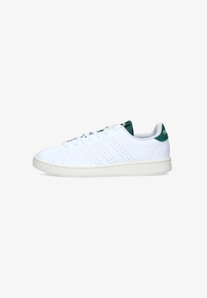 Sneaker bianca con design perforato sui lati, linguetta verde sul tallone e suola bianca testurizzata. Presenta lacci rotondi e branding minimalista.