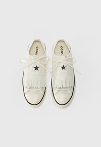 Baskets blanches en cuir lisse avec des détails en franges, accents d'étoile noire et un capuchon en caoutchouc à l'avant. Présente un design classique à lacets.