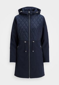 Marineblauwe gewatteerde jas met een gestikte bovenkant, capuchon, volledige rits, trekkoord in de taille en twee voorzakken. Soepele textuur, modern ontwerp.