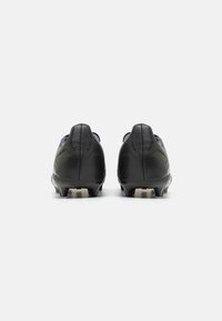 Botas de fútbol negras con un acabado de cuero suave, perforaciones sutiles y un diseño de perfil bajo. Tachuelas de TPU para tracción en superficies de hierba.
