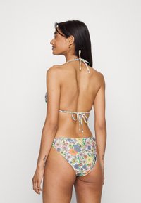 Conjunto de biquíni floral com padrão de flores multicoloridas. Tecido suave, decote halter com laço e parte de baixo de cintura alta com costura decorativa.