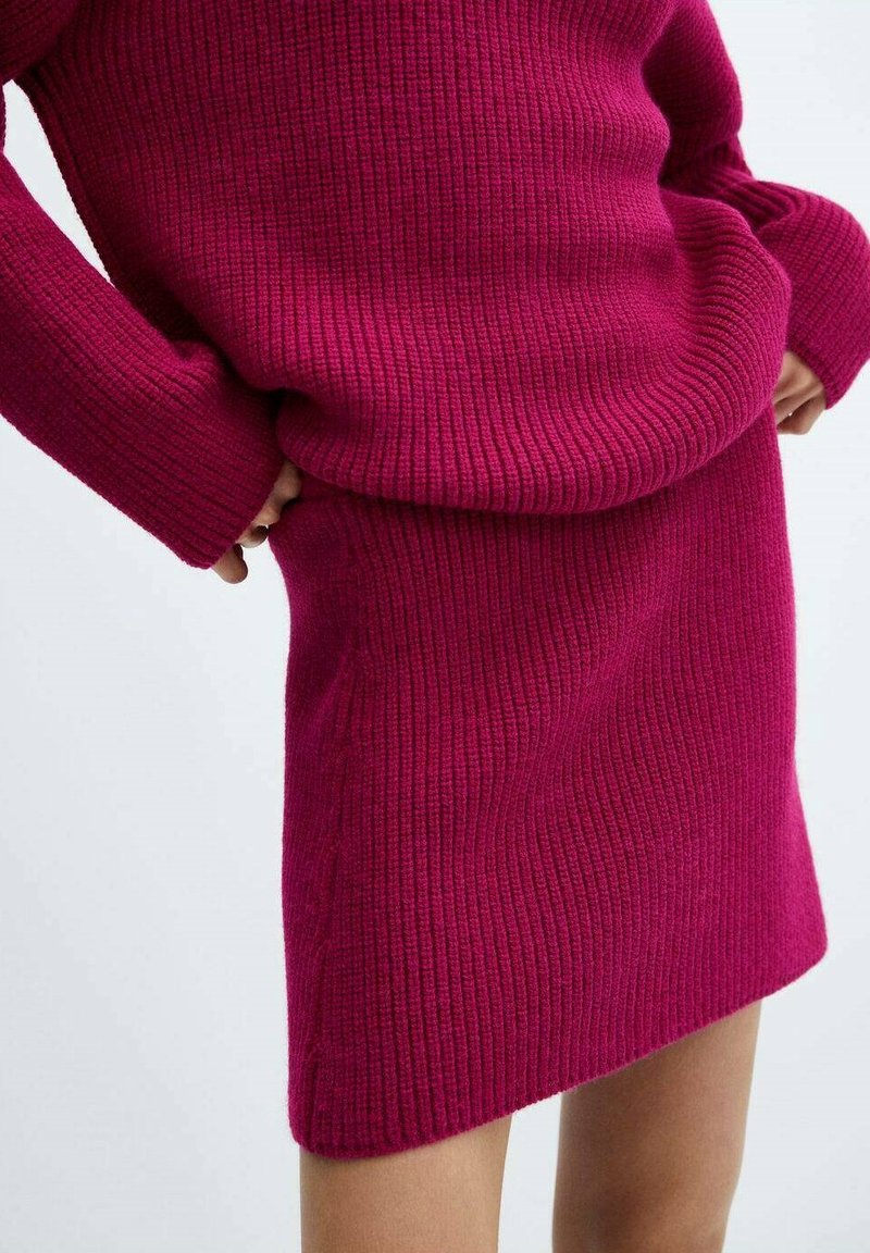 Fuksija rebrasta pletena bluza in krilo, ki vključuje dolge rokave in tesno prileganje, ter se ponaša z mehko teksturo in ravno silhueto.