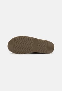 Suela de zapato de goma con un patrón de banda de rodadura en zigzag, de color marrón claro y superficie texturizada para una mejor tracción.