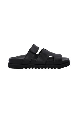 Black leather slide sandal with two wide straps, cut-out detailing, and textured sole for grip, featuring a flat footbed and adjustable strap.