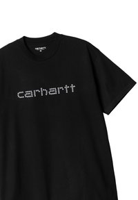 Camiseta negra de algodón con cuello redondo. Presenta un logo reflectante en plata de "carhartt" hecho de clavos circulares en el pecho.