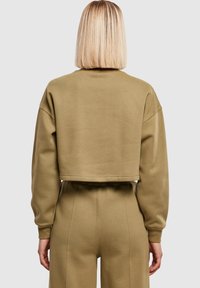 Afgeknipte, oversized sweatvest in olijfgroene fleece, met geribde manchetten en zoom. Gecombineerd met bijpassende hoge taille broek.