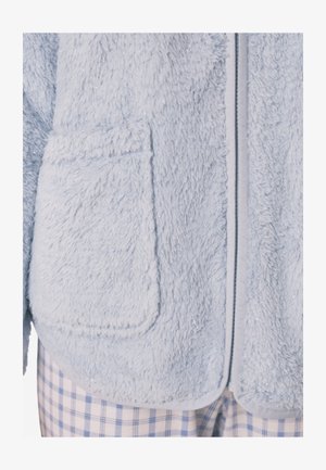 Light blue fuzzy fleece jacket with a soft texture, featuring two front pockets and a zip closure outlined in a contrasting trim.
