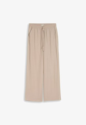Pantalon beige à jambes larges avec taille élastique, cordon de serrage, poches latérales et une discrète bordure blanche le long des coutures extérieures.