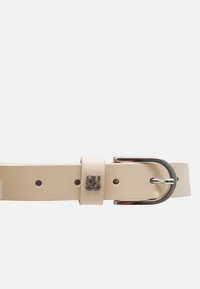 Cintura in pelle beige con fibbia argentata. Presenta un passante con la scritta "HUGO" in rilievo. Design dritto con forature per la regolazione della misura.