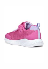 Sneaker rose avec tissu en maille, accents en synthétique, une sangle Velcro et une semelle blanche texturée avec un motif en vagues.