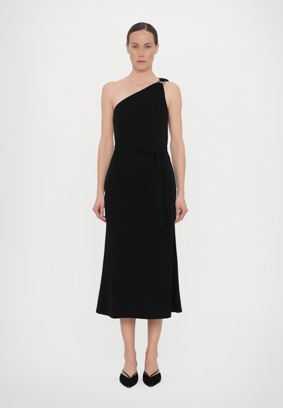 Vestido negro sin mangas de un solo hombro hecho de tela suave, con cintura anudada y falda hasta la rodilla con un ligero vuelo.
